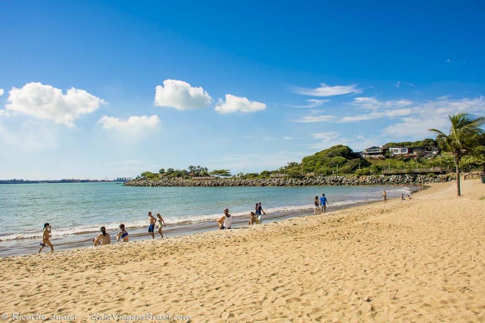 Imagem de pessoas caminhando na beira da Praia de Cambori.